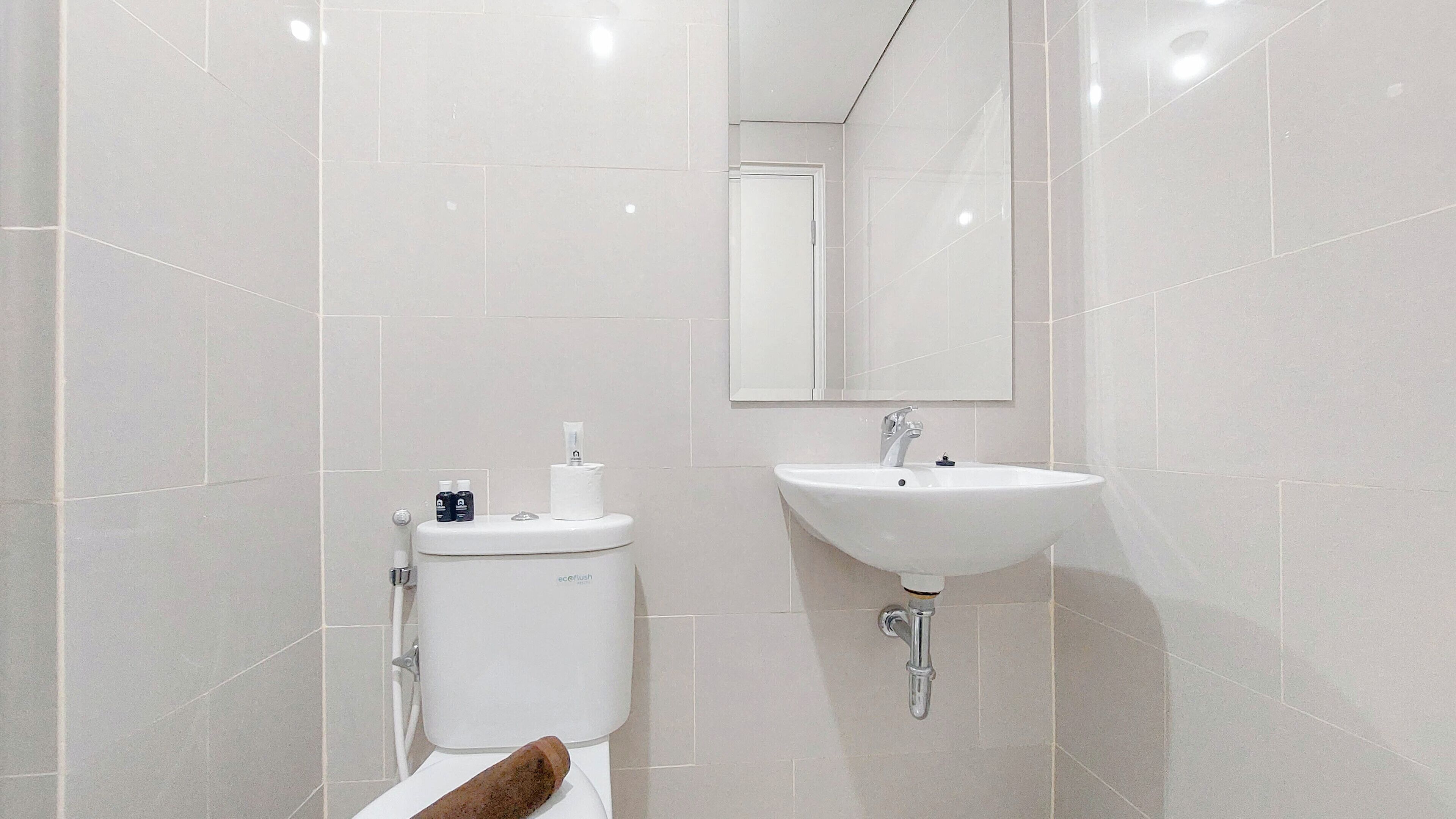 Een moderne badkamer met toilet, wastafel en spiegel.