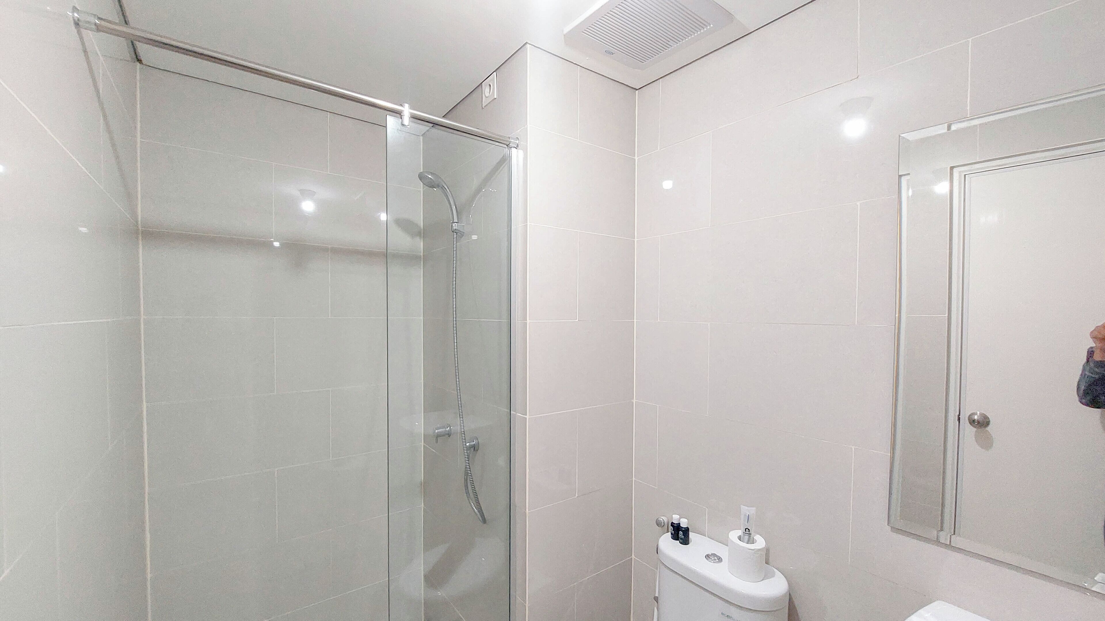 Un bagno moderno con doccia vetrata, un water e un lavandino.