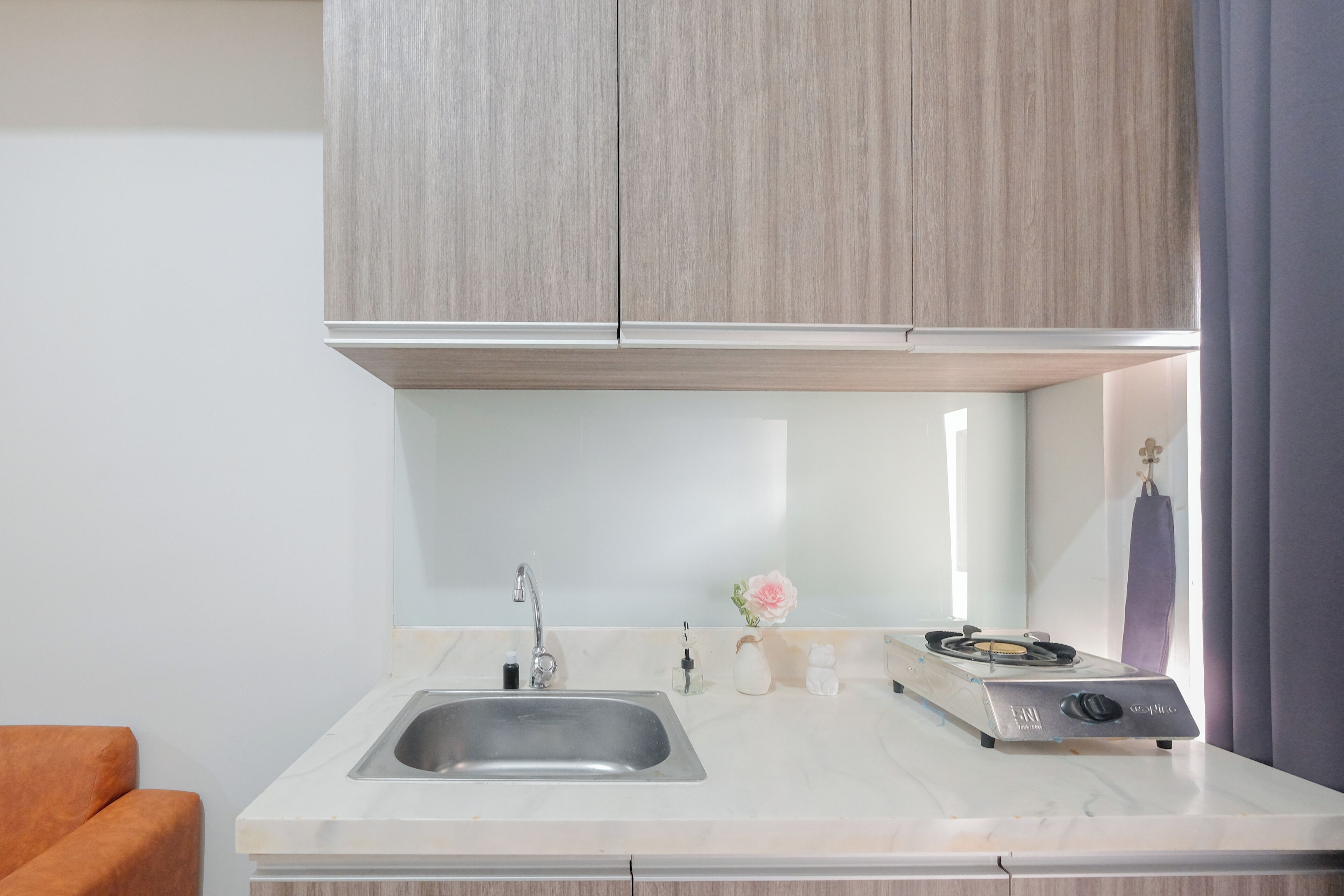 A modern kitchen with a stainless steel sink, a gas stove, and wooden cabinets.