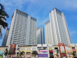 Experience the vibrant urban atmosphere of this bustling city, surrounded by a mix of shops and services.