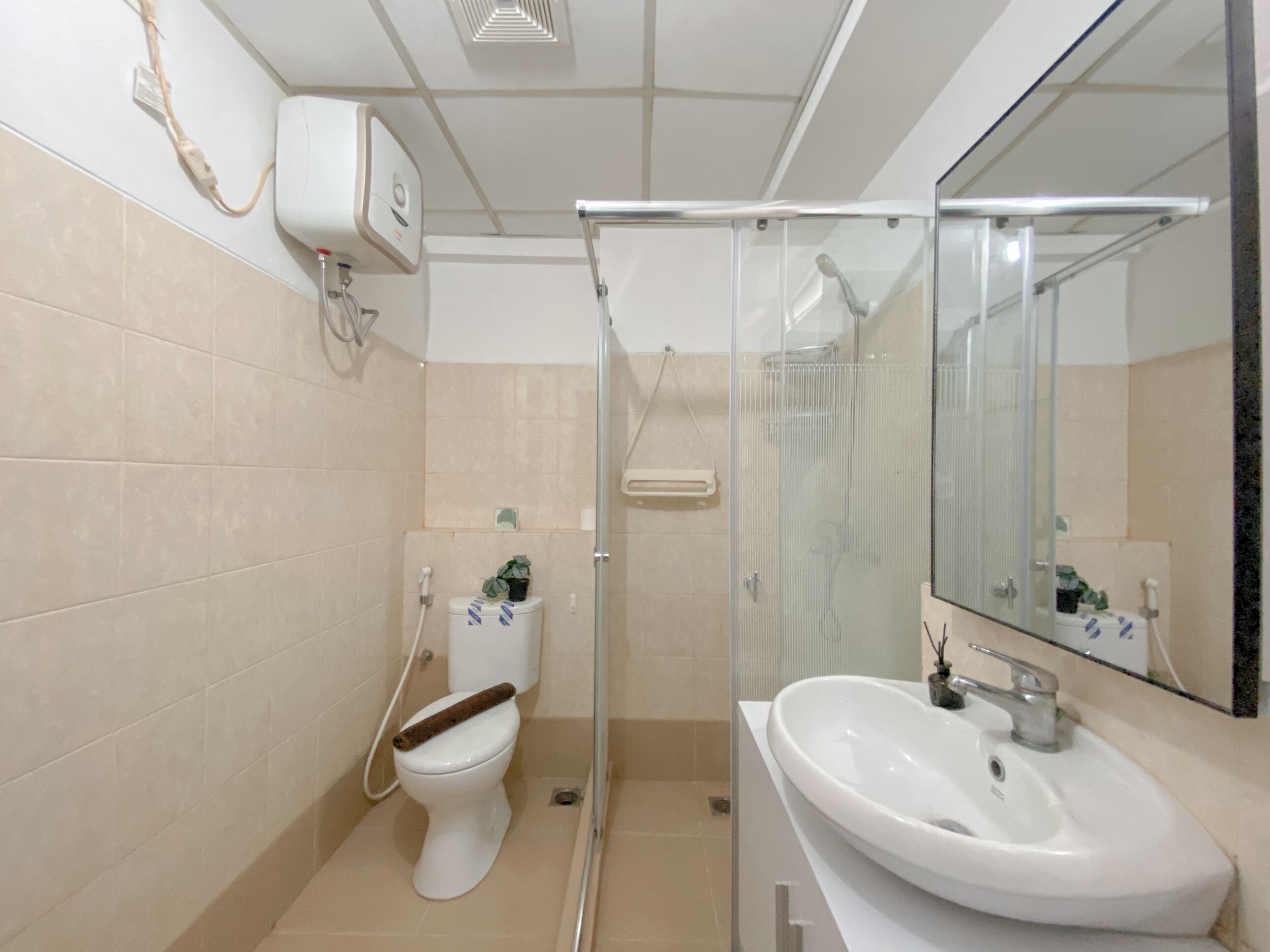 Un baño con inodoro, lavabo, cabina de ducha y espejo.