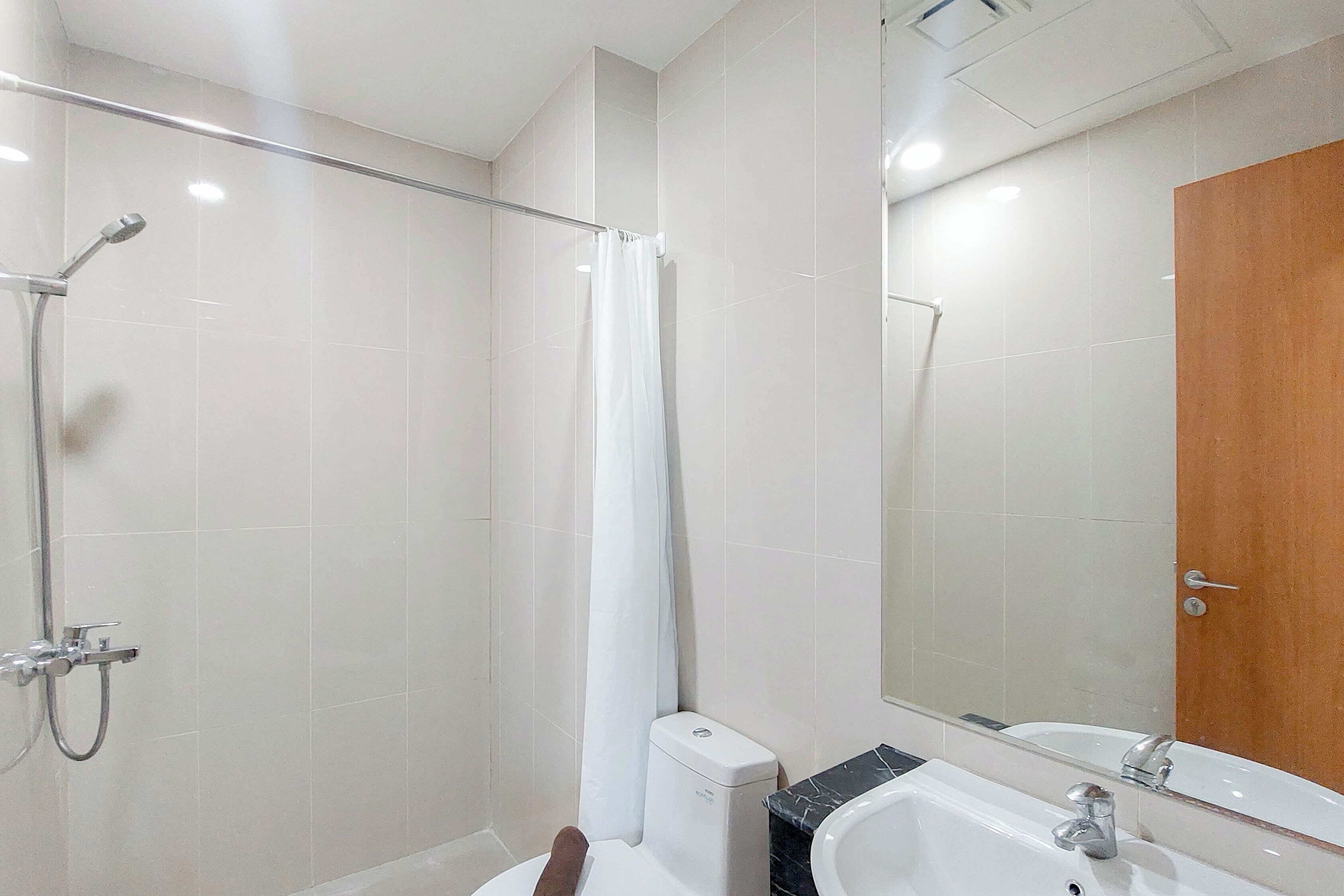 A modern bathroom with a shower, toilet, and sink.