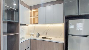 Egy modern konyha beépített háztartási gépekkel, mosogatóval és kávéfőzővel.