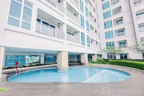 Un bâtiment moderne doté d’une piscine, de nombreux balcons et d’un jardin bien entretenu.
