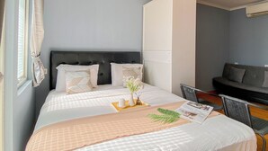 Een hotelkamer met een bed, een zithoek en een raam met gordijnen.