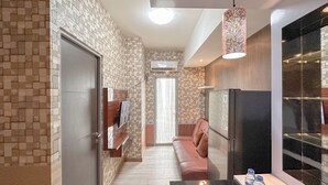 A modern kitchen with a built-in refrigerator, a hanging light fixture, and a glass-fronted pantry. - 1BR Modern Suites at Tamansari Prospero Sidoarjo Apartment (Sidoarjo)