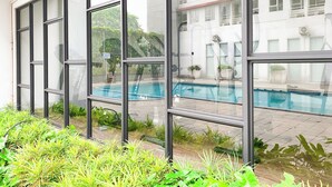 Un edificio moderno con grandes ventanales que dan a una piscina.