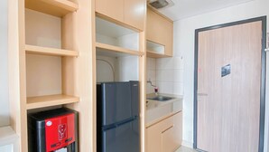 Una cocina con armarios de madera, un refrigerador negro, un lavamanos y un dispensador de agua.