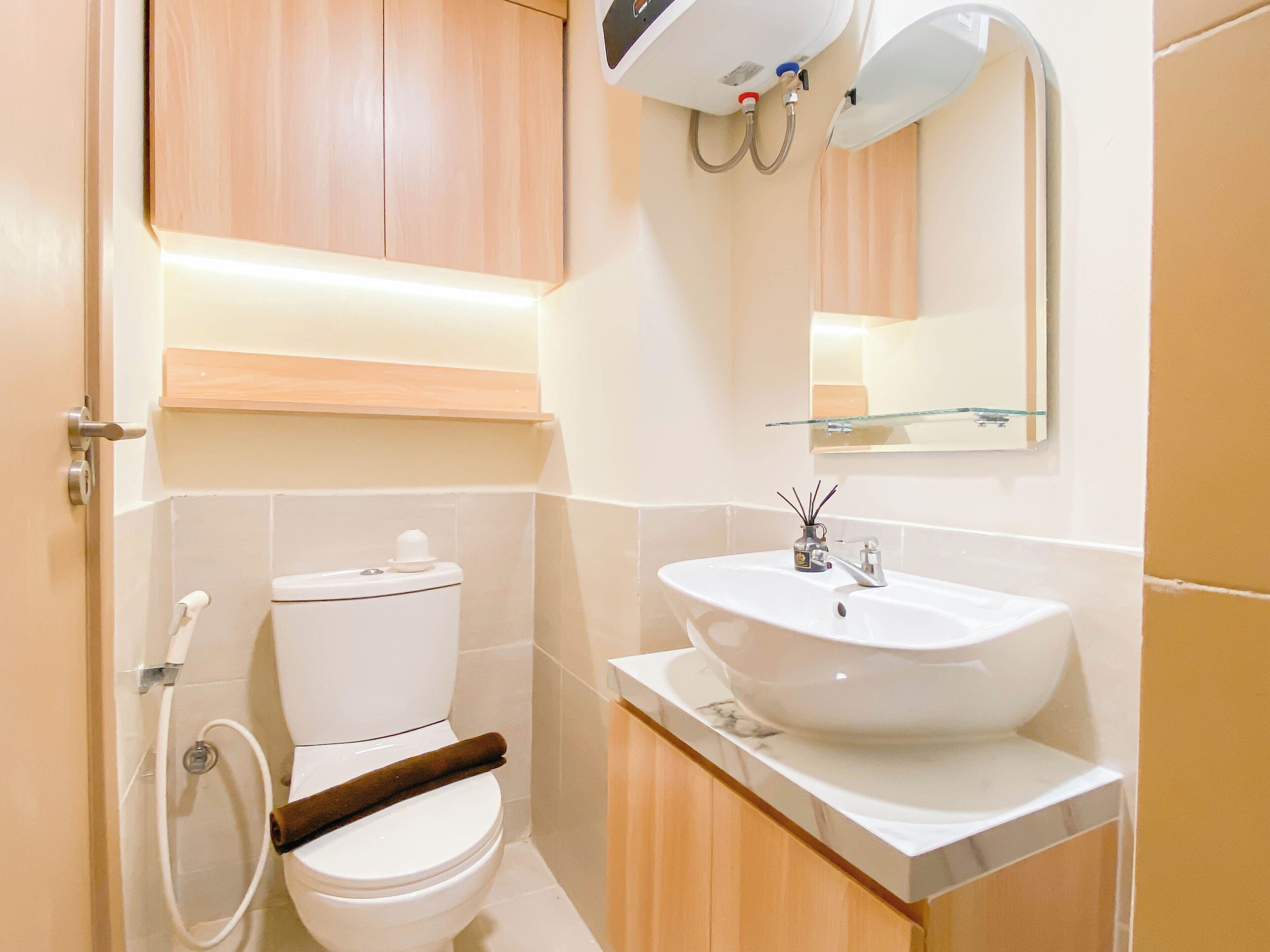 A bathroom with a toilet, a sink, and a mirror.