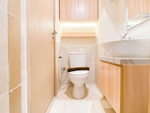 Un baño pequeño y moderno con inodoro, ducha y lavabo.