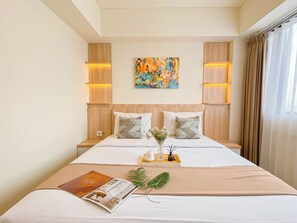 Una habitación de hotel con una cama grande, un cuadro en la pared y una revista sobre la cama.