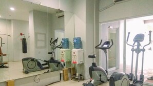 A gym with exercise equipment, a large mirror, and water dispensers.