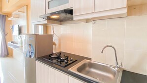 A modern kitchen with a gas stove, stainless steel sink, and wooden cabinets.