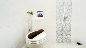 A bathroom with a toilet, a shower, and a tiled wall. - Nice and Comfy 2BR at 32th Floor Tokyo Riverside PIK 2 Apartment (Teluknaga)