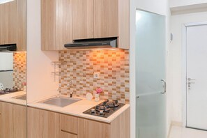 Private kitchen - Warm and Well Designed Studio Room at Green Pramuka City Apartment (Jakarta)