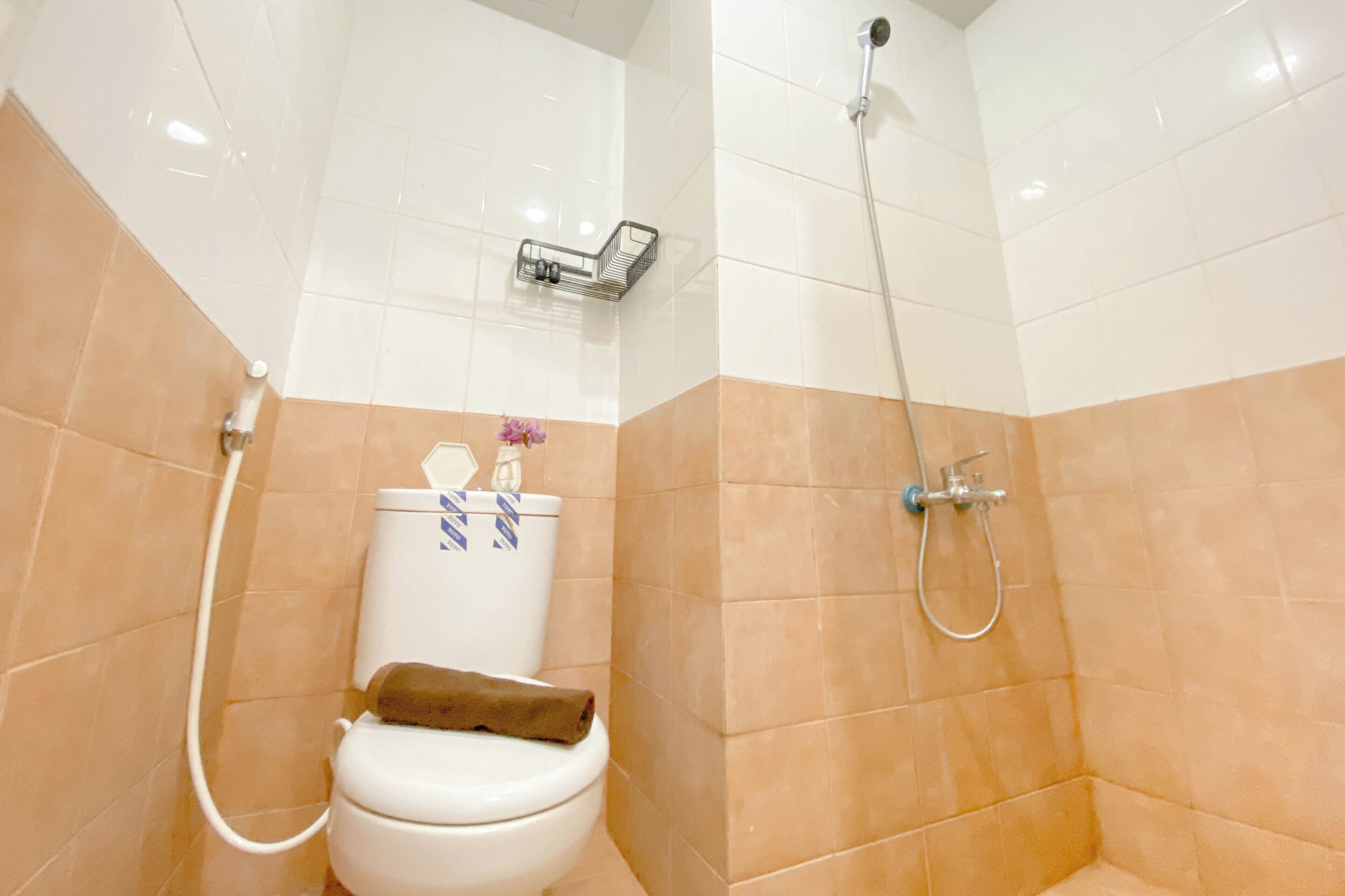 A bathroom with a toilet, a shower, and a towel rack.