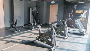 A gym with exercise equipment, including treadmills and weight machines. - Comfy and Warm Studio at The Square Surabaya Apartment (Surabaya)