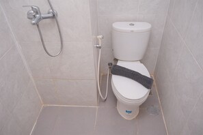 A bathroom with a toilet, a shower, and a wall-mounted faucet. - Combined and Spacious 1BR Apartment at Parkland Avenue (South Tangerang)