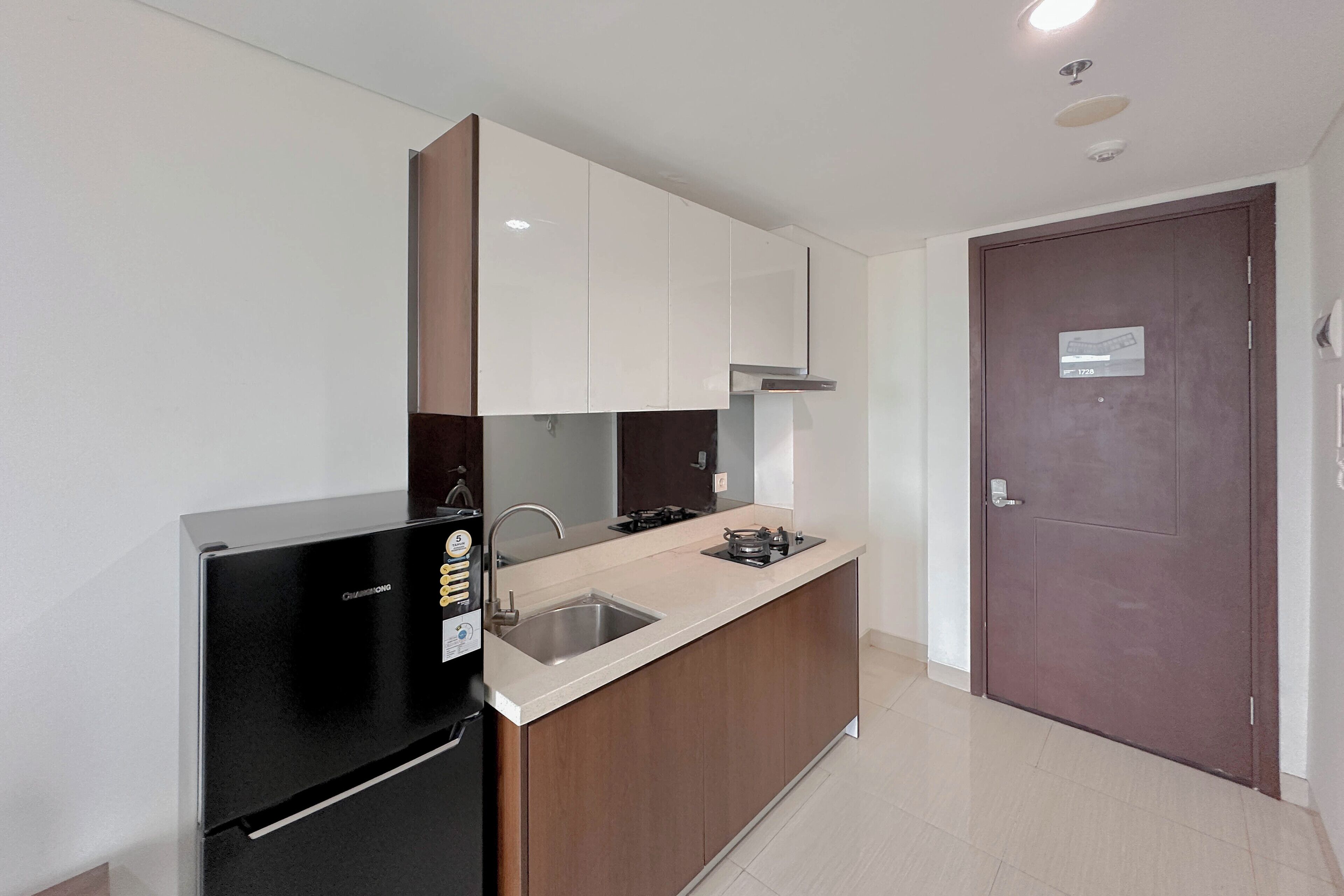 Una cocina moderna con refrigerador, lavamanos y estufa.