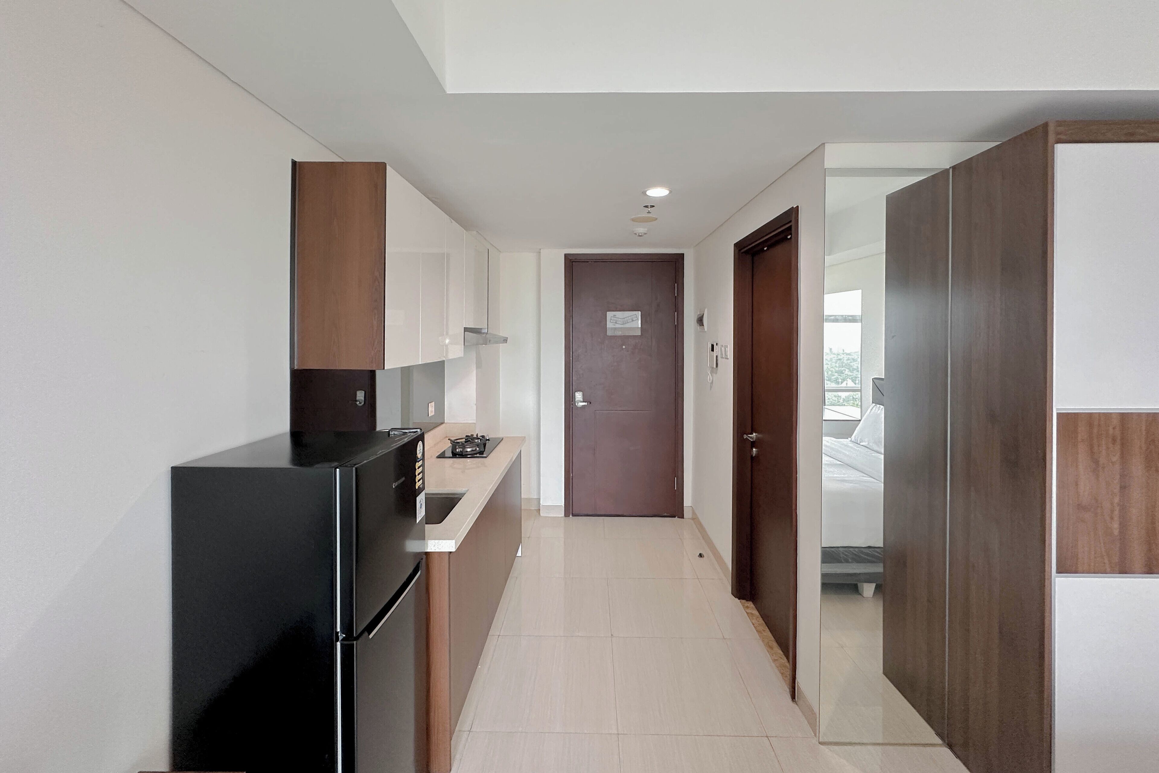 A modern kitchen with a black refrigerator, wooden cabinets, and a countertop.