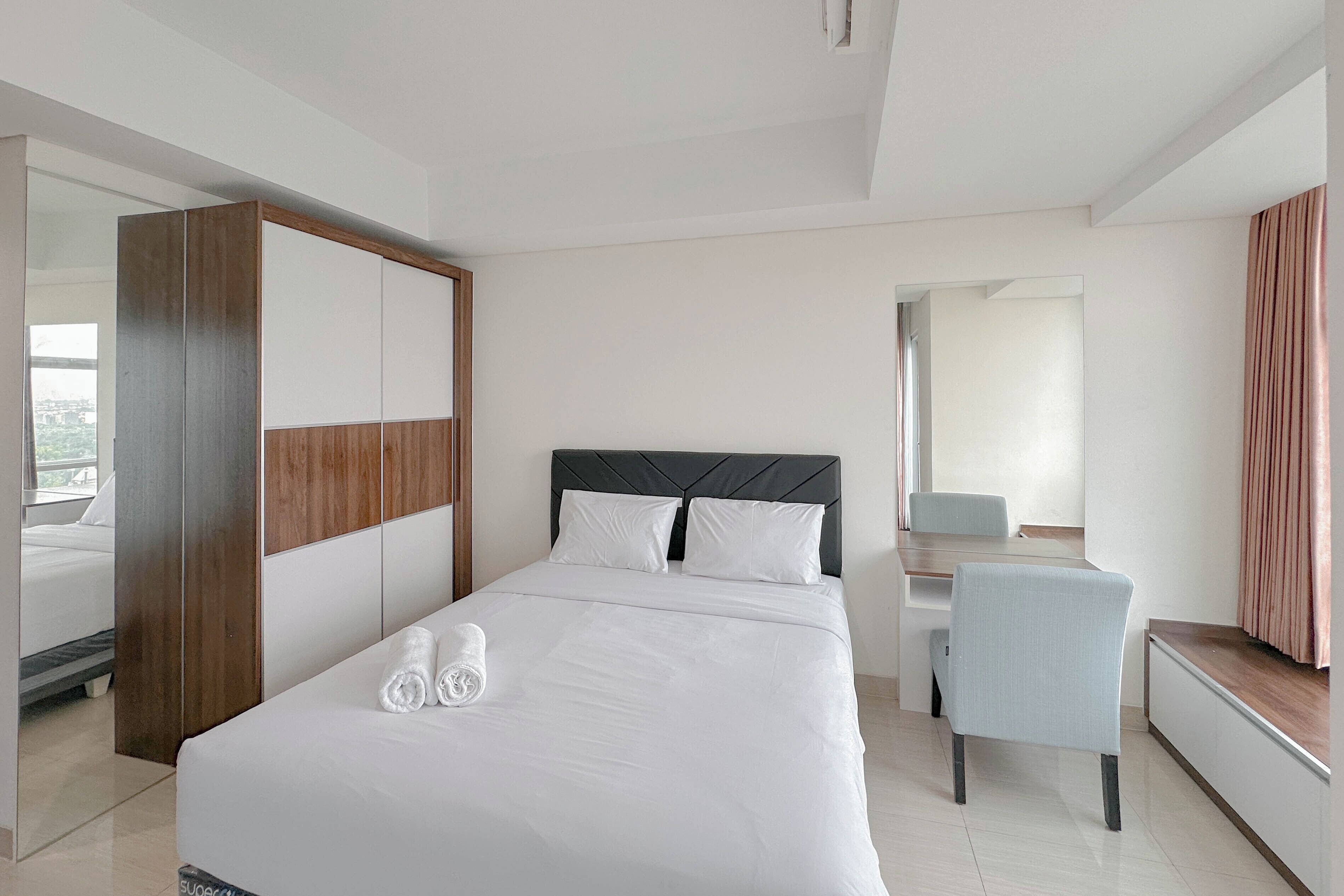 Una habitación de hotel moderna con una cama grande, un escritorio y una silla.