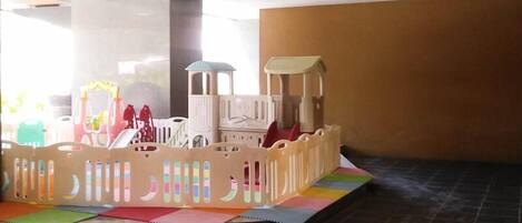 A play area with a soft play structure and colorful mats.