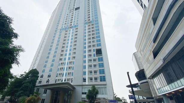 A tall, modern building with a prominent entrance and multiple floors. - Tidy and Strategic Location Studio Grand Sungkono Lagoon Apartment (Surabaya)