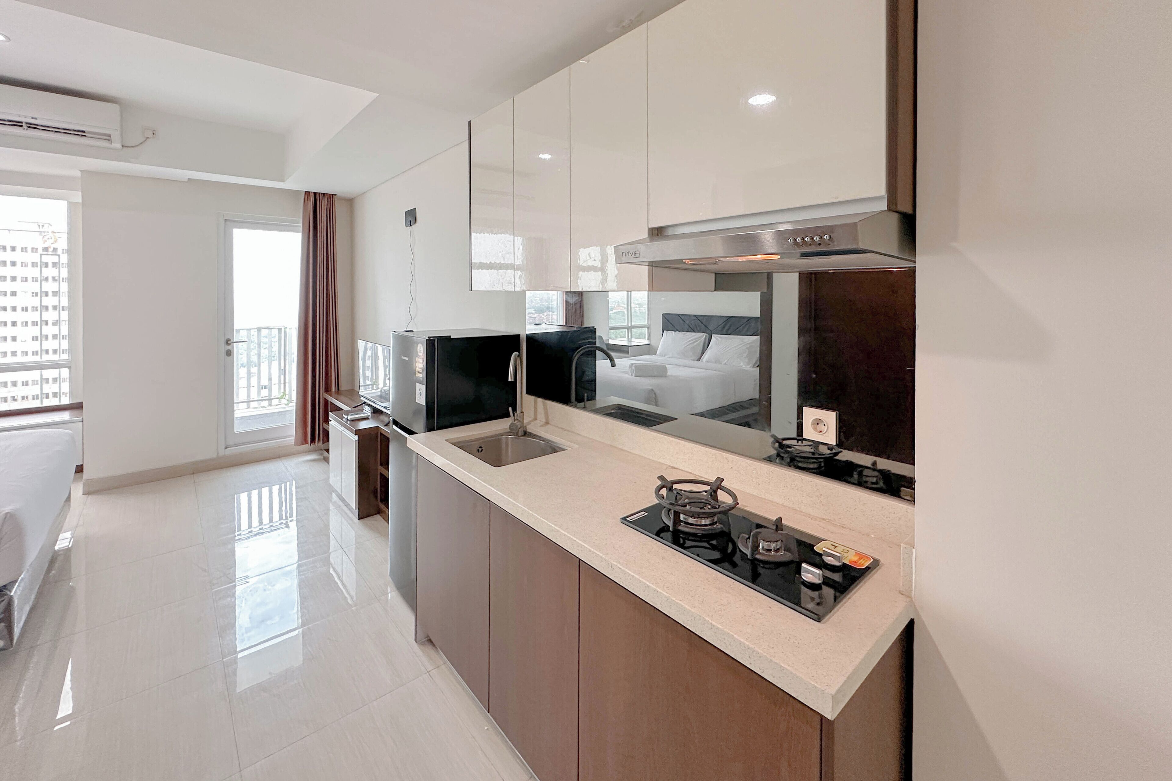 A modern kitchen with a large island, a built-in oven, and a microwave.