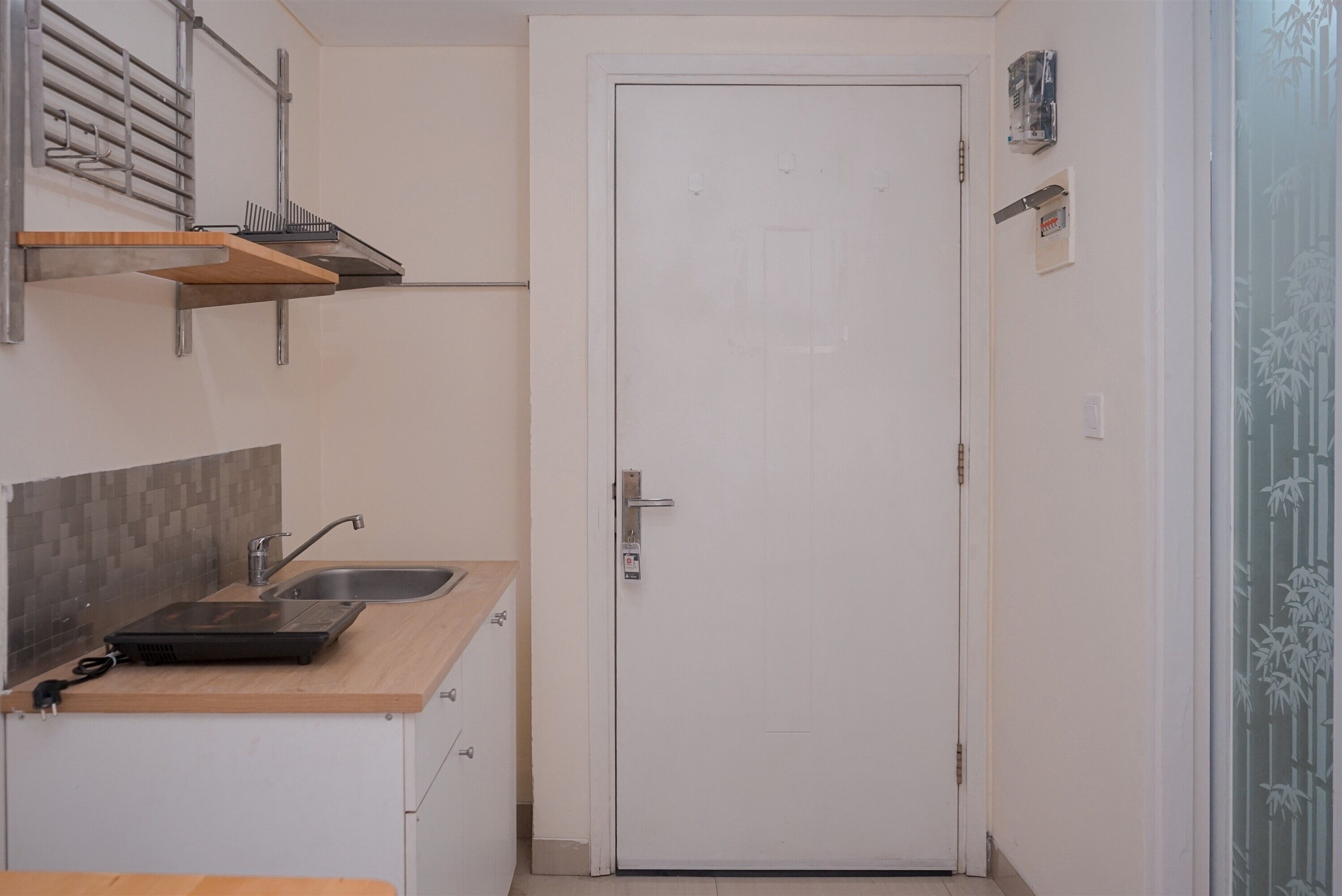 A compact kitchen with a sink, countertop, and a white door.