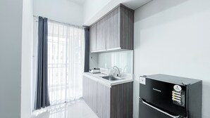 Una cocina moderna con estufa integrada, lavamanos y un refrigerador negro.