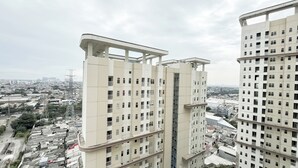 Un edificio alto con varios balcones y vistas de la ciudad circundante.