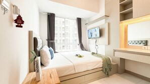 Ein modernes Hotelzimmer mit einem Bett, einem Fernseher, einem Spiegel und einem Fenster mit Vorhängen.