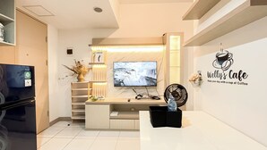 Ein modernes Wohnzimmer mit Fernseher, Wandkunst zum Thema Kaffee und einer gemütlichen Sitzecke.