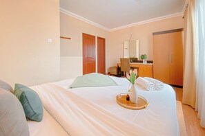 Une chambre d’hôtel comprenant un lit, un bureau, une chaise, une armoire et une salle de bain.