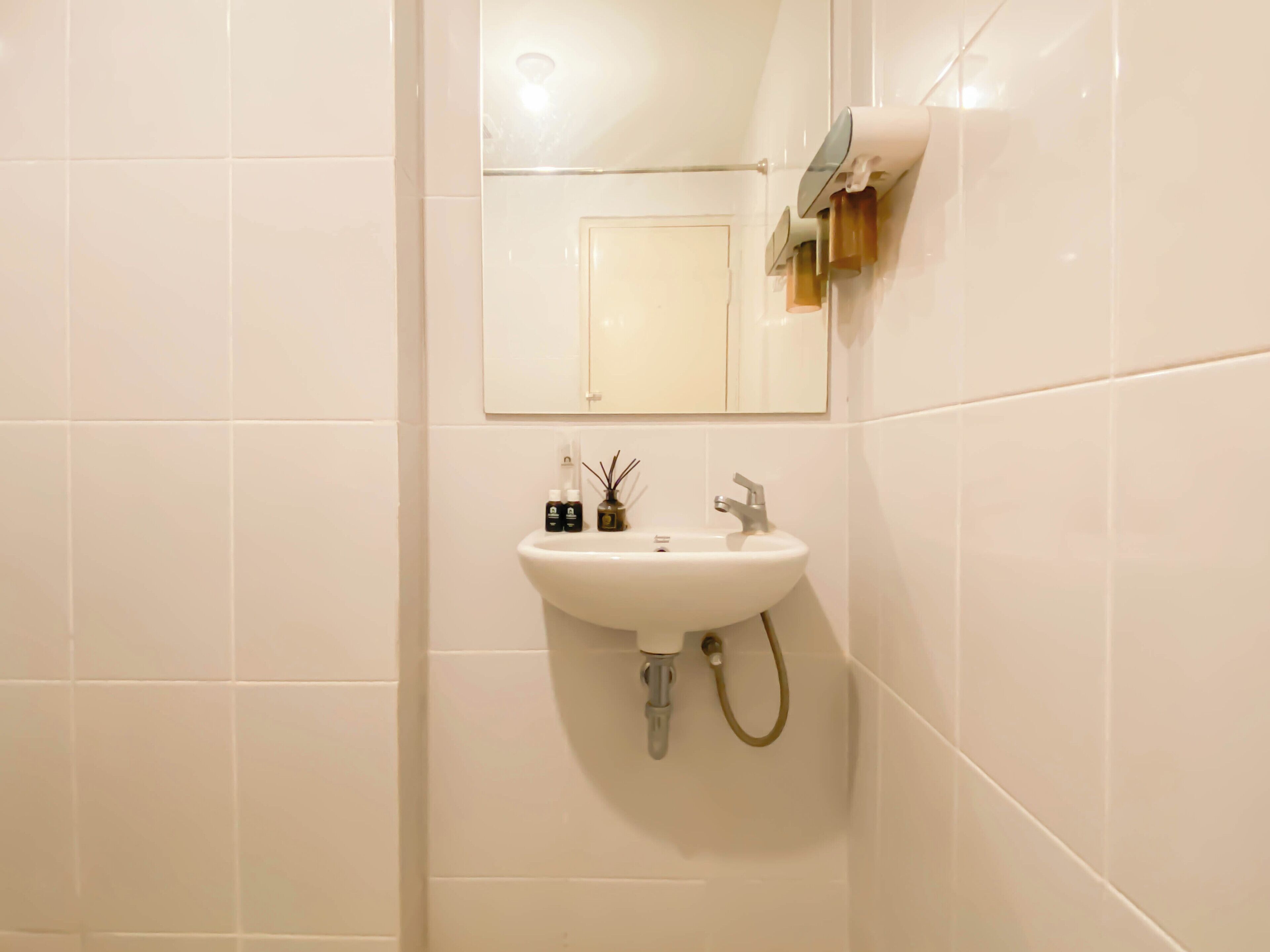 Ein Badezimmer mit Waschbecken, Spiegel und gefliesten Wänden.