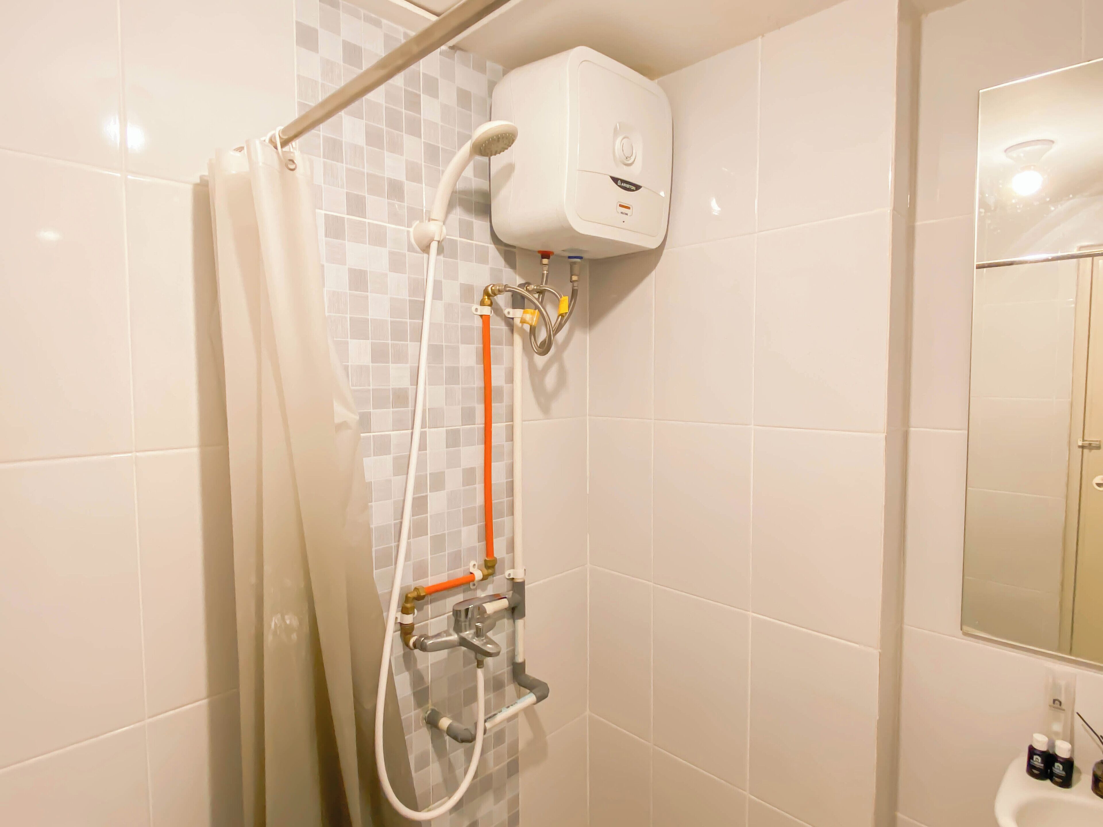 A bathroom with a shower, a toilet, and a sink.