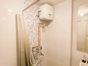 A bathroom with a shower, a toilet, and a sink.