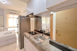A modern kitchen with a stainless steel refrigerator, a gas stove, and a sink. - Comfortable Stay and Good Place Studio at Bale Hinggil Apartment (Surabaya)
