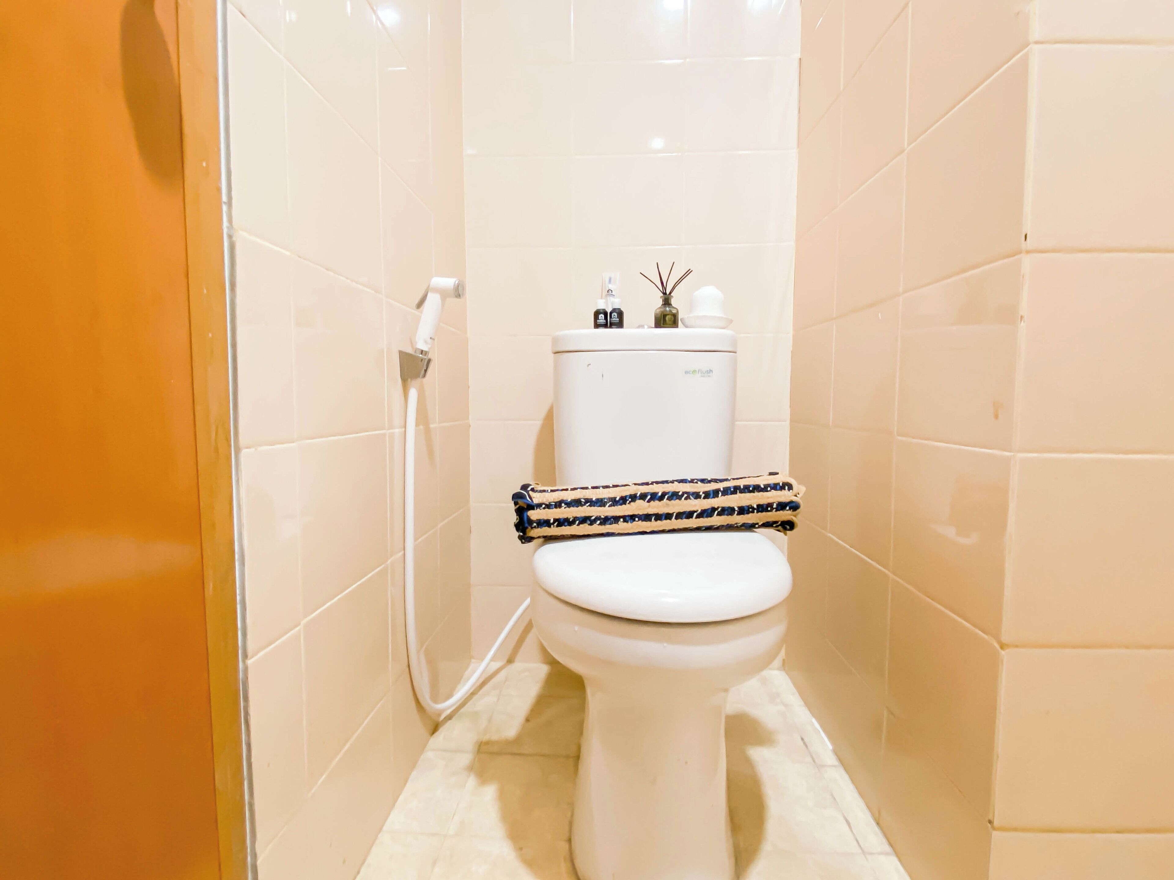 A small, modern bathroom with a white toilet, a shower area, and a tiled floor.