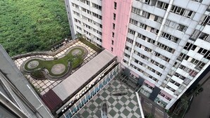 A high-rise building with a rooftop garden, multiple balconies, and a mix of residential and commercial spaces. - Well Designed and Comfortable 3BR Nifarro Park Apartment (Jakarta)