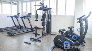 A gym with treadmills, a weight machine, and an elliptical. - Cozy and Relaxing Studio Room at De Prima Apartment (Medan)