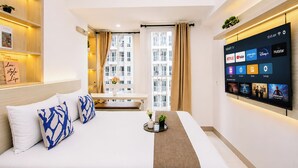 A modern hotel room with a bed, bedside table, and a wall-mounted TV displaying streaming services. - Cozy and Good Place Studio Apartment Tokyo Riverside PIK 2 (Teluknaga)