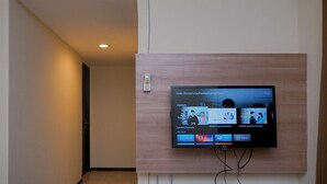 A flat-screen TV mounted on a wall with a wooden panel, displaying a user interface with various options and a clock showing 10:31.