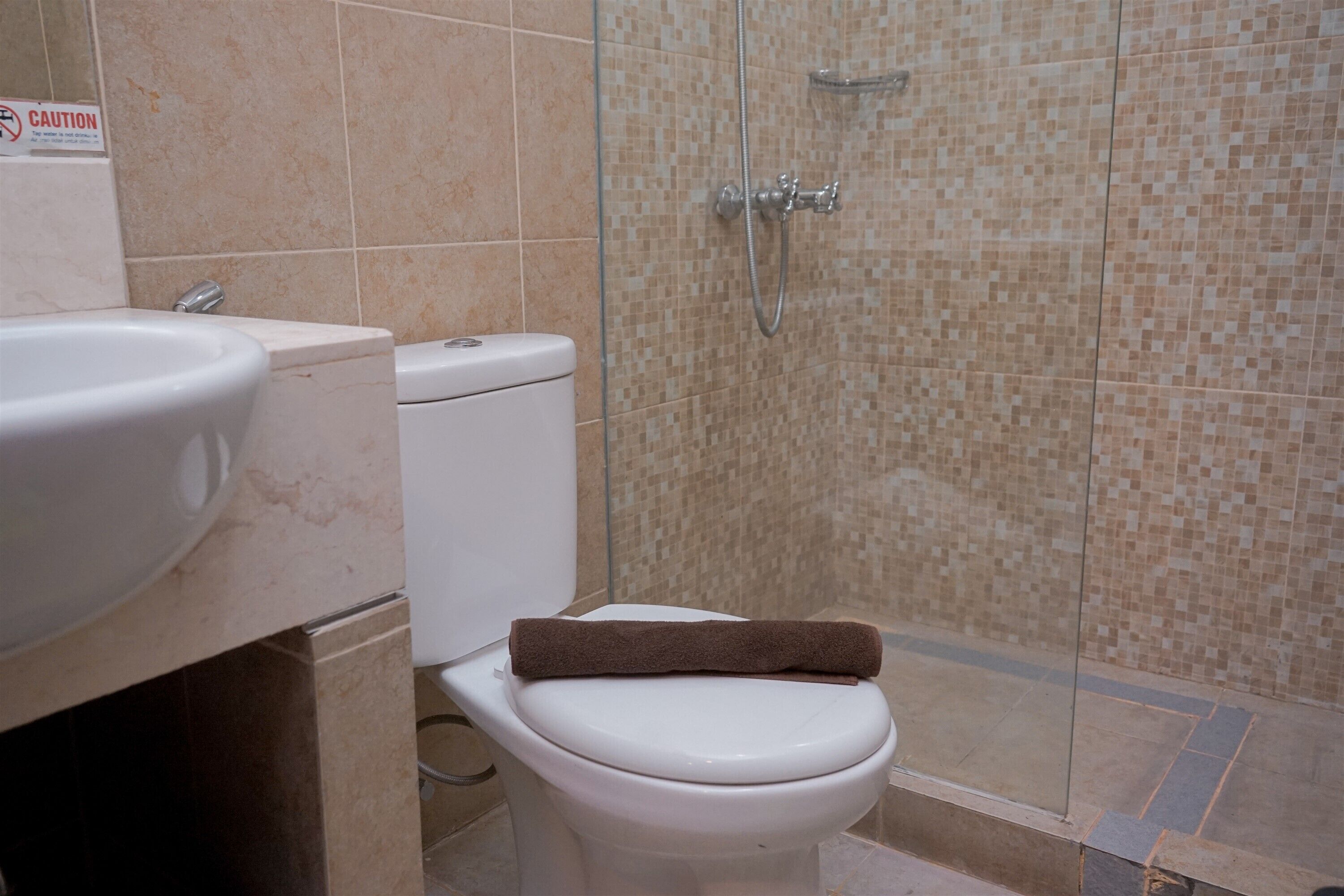 A bathroom with a toilet, sink, and shower area.