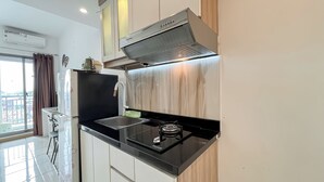 A modern kitchen with a black stove, stainless steel sink, and a built-in oven.
