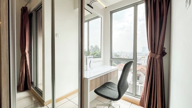 A modern room with a large window, a desk, and a chair. - Modern Living Studio Room Apartment M-Town Residence (Gading Serpong)