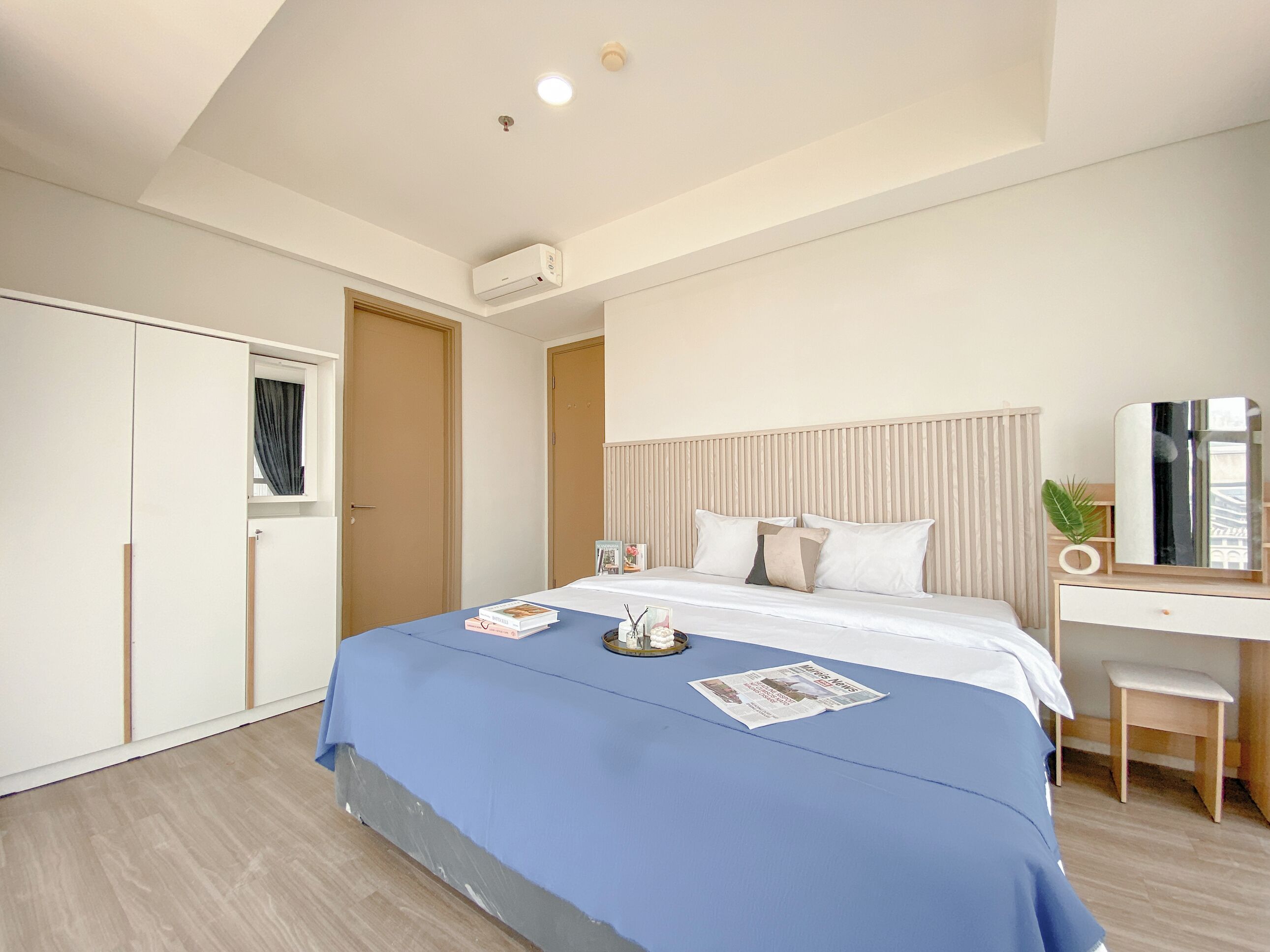 A modern bedroom with a bed, bedside table, and a desk with a chair.