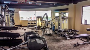 A gym with various exercise equipment, benches, and dumbbells. - Cozy Studio at Atria Residence Gading Serpong Apartment (Gading Serpong)