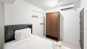 Un dormitorio con cama, armario, aire acondicionado y luz de techo.
