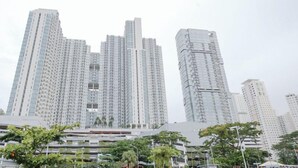 A high-rise residential building with multiple balconies and a modern architectural design. - Cozy and Spacious 1BR at Anderson Supermall Mansion Apartment (Surabaya)